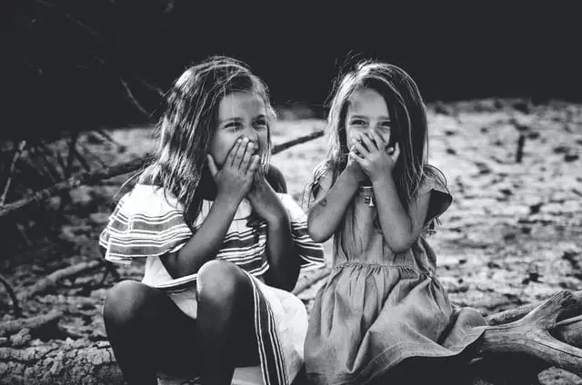 Kinder halten sich Hand vor den Mund