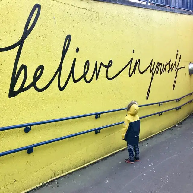 Kind vor Schriftzug "believe in yourself"