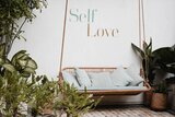 Hängematte und Aufschrift "Self Love" auf der Wand