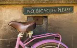 Fahrrad vor Schild mit Aufschrift "No bicycles please"