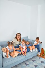 Frau mit Kindern auf einer Couch