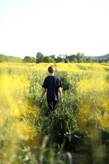 Kind mit dem Rücken zur Kamera in der Natur