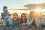 Kinder liegen an einem Strand