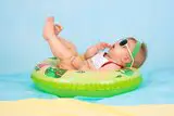 Baby auf Schwimmring mit Sonnenbrille