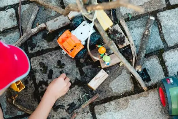 Kind mit Spielsachen im Außenbereich