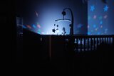 Kinderbett im dunklen Zimmer mit Beleuchtung an der Wand 