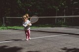 Kind mit Tennisschläger in der Hand 