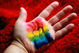 Handfläche mit Regenbogen und Herz 