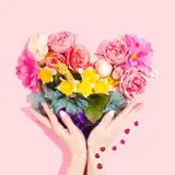 Hand hält Blumen in Herzform 