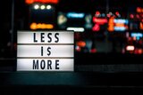 Schwarze Schrift "Less is more" auf hell beleuchtetem Hintergrund 